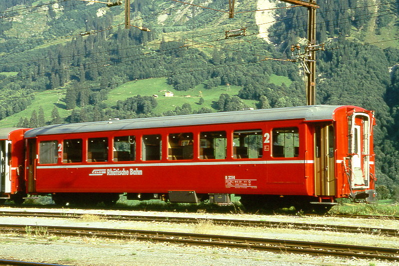 RhB - B 2114 am 27.08.1997 in Disentis - 2.Klasse Leichtstahlwagen, geeignet f�r Krankentransporte der Armee - �bernahme 17.03.1913 - SIG - Fahrzeuggewicht 19,10t - Sitzpl�tze 64, Stehpl�tze 20 - L�P 15,77m - zul�ssige Geschwindigkeit 90 km/h - mit eingebauten Bremszahnrad - �3=16.12.1993 - Lebenslauf: ex C4 2214 - 1930 C4� 2214 - 1961 Sanit�tswagen - 1964 B 2214 - 04/2005 DFB B 2214 - 2009 la Baie/F - Hinweis: Logo RhB in deutsch - Griffstangen neben den T�ren, Klassezahlen gro�, hoher Anschriftenblock, dicke Betriebsnummern.
