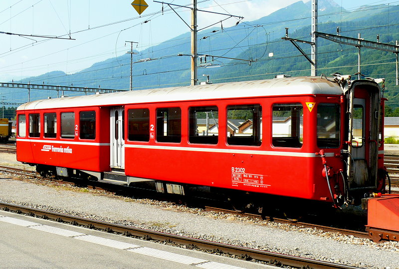 RhB - B 2302 am 13.07.2013 in Landquart - 2.Klasse Personenwagen - Mitteleinstiegswagen leichte Stahlbauart - Baujahr 1939 - SWS/SIG - Fahrzeuggewicht 17,00t - Sitzpl�tze 64 - L�P 17,73m - zul�ssige Geschwindigkeit 90 km/h - Logo RhB in italienisch - �2=7.12.1992 - �121.08.2009 - Lebenslauf: ex C4 2303 - 1956 B4� 2303 - 1964 B 2303 - Hinweis: Kennzeichnung an den Ecken offene gelbe Dreiecke mit wei�en Punkt - die Fahrzeugserie bestand aus 6  Wagen mit den Nummern 2301 bis 2306 f�r Schnellz�ge Fliegender Rh�tier mit ABe 4/4 501 - 504. 
