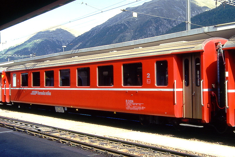 RhB - B 2424 am 31.08.1993 in Samedan - 2.Klasse Einheitspersonenwagen (Typ II) - �bernahme 29.06.1979 - FFA/SWP/RhB - Fahrzeuggewicht 15,00t - Sitzpl�tze 52/Stehpl�tze 24 - L�P 18,50m - zul�ssige Geschwindigkeit 90 km/h - �2=16.06.1993 - Logo RhB in italienisch - Klassezahlen klein, Griffstangen neben den T�ren - Hinweis: Die Fahrzeugserie besteht aus 30 Wagen mit den Nummern 2421 bis 2450. 
