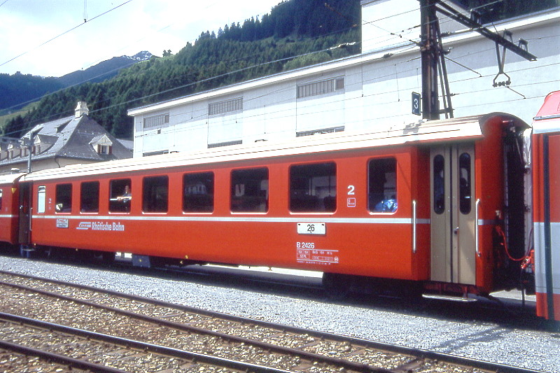 RhB - B 2426 am 06.06.1993 in Disentis - 2.Klasse Einheitspersonenwagen (Typ II) - �bernahme 26.07.1979 - FFA/SWP/RhB - Fahrzeuggewicht 15,00t - Sitzpl�tze 52/Stehpl�tze 24 - L�P 18,50m - zul�ssige Geschwindigkeit 90 km/h - �2=01.07.1988 - Logo RhB in deutsch - Klassezahlen klein, Griffstangen neben den T�ren - Hinweis: Die Fahrzeugserie besteht aus 30 Wagen mit den Nummern 2421 bis 2450. 
