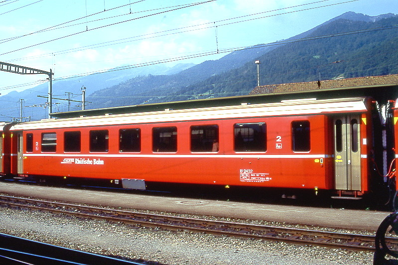 RhB - B 2432 am 19.08.1995 in Landquart - 2.Klasse Einheitspersonenwagen (Typ II) - �bernahme 23.10.1979 - FFA/SWP - Fahrzeuggewicht 15,00t - Sitzpl�tze 52 - L�P 18,50m - zul�ssige Geschwindigkeit 90 km/h - �2=02.09.1994 - Logo RhB in deutsch - Klassezahlen klein, Griffstangen neben den T�ren entfernt, gelbe Taster neben den T�ren, Kennzeichnung an den Ecken gelb - Hinweis: Die Fahrzeugserie bestand aus 30 Wagen mit den Nummern 2421 bis 2450. 
