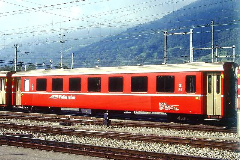 RhB - B 2442 am 09.06.1996 in Landquart - 2.Klasse Einheitspersonenwagen (Typ II) - �bernahme 26.02.1980 - FFA/SWP - Fahrzeuggewicht 15,00t - Sitzpl�tze 52 - L�P 18,50m - zul�ssige Geschwindigkeit 90 km/h - �=07.10.1994 - Logo RhB in r�toromanisch - kleine Klassezahlen - Kennzeichnung an den Ecken gelb - Hinweis: Die Fahrzeugserie besteht aus 30 Wagen mit den Nummern 2421 bis 2450. 
