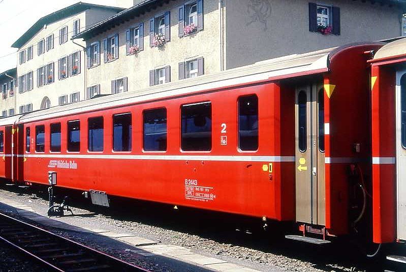 RhB - B 2443 am 07.09.1994 in St.Moritz - 2.Klasse Einheitspersonenwagen (Typ II) - �bernahme 10.03.1980 - FFA/SWP - Fahrzeuggewicht 15,00t - Sitzpl�tze 52 - L�P 18,50m - zul�ssige Geschwindigkeit 90 km/h - �2=15.11.1988 - Logo RhB in deutsch - gelbe Hinweispfeile an den T�ren f�r Taster - Kennzeichnung an den Ecken gelb - Hinweis: Die Fahrzeugserie besteht aus 30 Wagen mit den Nummern 2421 bis 2450. 
