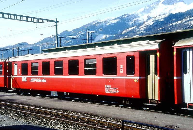 RhB - B 2443 am 17.03.1999 in Landquart - 2.Klasse Einheitspersonenwagen (Typ II) - �bernahme 10.03.1980 - FFA/SWP - Fahrzeuggewicht 15,00t - Sitzpl�tze 52 - L�P 18,50m - zul�ssige Geschwindigkeit 90 km/h - �2=04.11.1994 - Logo RhB in r�toromanisch - mit Taster - Kennzeichnung an den Ecken gelb - Hinweis: Die Fahrzeugserie besteht aus 30 Wagen mit den Nummern 2421 bis 2450. 
