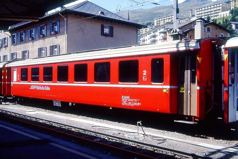RhB - B 2448 am 31.08.1993 in St.Moritz - 2.Klasse Einheitspersonenwagen (Typ II) - �bernahme 15.10.1980 - FFA/SWP - Fahrzeuggewicht 15,00t - Sitzpl�tze 52 - L�P 18,50m - zul�ssige Geschwindigkeit 90 km/h - �2=11.01.1989 - Logo RhB in deutsch - gelbe Hinweispfeile an T�ren f�r Taster neben den T�ren - Kennzeichnung an den Ecken gelb - Hinweis: Die Fahrzeugserie besteht aus 30 Wagen mit den Nummern 2421 bis 2450. 
