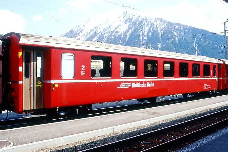 RhB - B 2448 am 10.05.1994 in Davos Dorf - 2.Klasse Einheitspersonenwagen (Typ II) - �bernahme 15.10.1980 - FFA/SWP - Fahrzeuggewicht 15,00t - Sitzpl�tze 52 - L�P 18,50m - zul�ssige Geschwindigkeit 90 km/h - �2=11.01.1989 - Logo RhB in deutsch - gelbe Hinweispfeile an T�ren f�r Taster neben den T�ren - Kennzeichnung an den Ecken gelb - Hinweis: Die Fahrzeugserie besteht aus 30 Wagen mit den Nummern 2421 bis 2450. 
