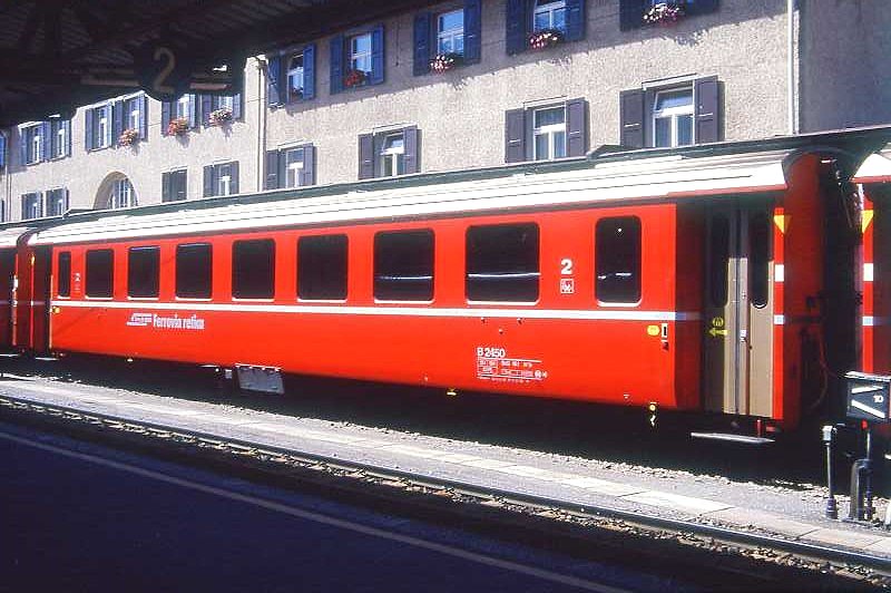 RhB - B 2450 am 31.08.1993 in St.Moritz - 2.Klasse Einheitspersonenwagen (Typ II) - �bernahme 08.12.1980 - FFA/SWP - Fahrzeuggewicht 15,00t - Sitzpl�tze 52 - L�P 18,50m - zul�ssige Geschwindigkeit 90 km/h - �2=01.02.1989 - Logo RhB in italienisch - gelbe Hinweispfeile auf T�ren f�r Taster neben den T�ren - Kennzeichnung an den Ecken gelb - Hinweis: Die Fahrzeugserie besteht aus 30 Wagen mit den Nummern 2421 bis 2450. 
