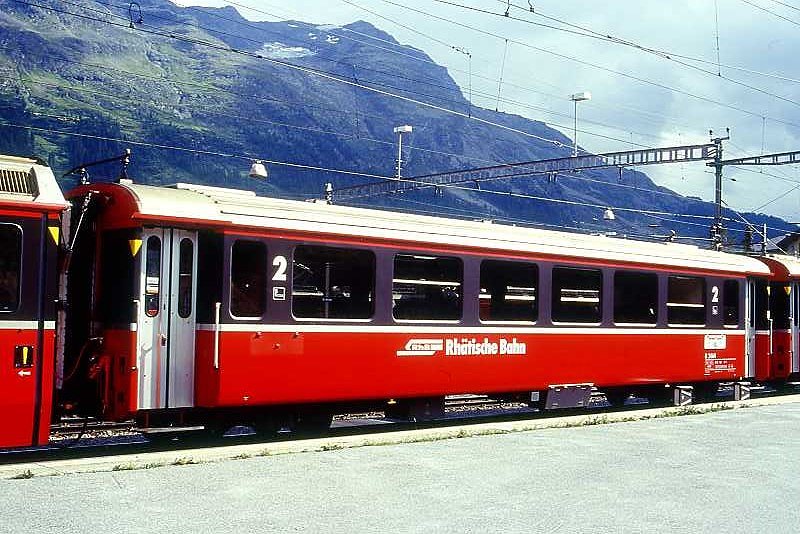 RhB - B 2464 am 20.08.1995 in Samedan - 2.Klasse verk�rzter Einheitspersonenwagen (Typ III) f�r Bernin-Express mit braunen Fensterband  - �bernahme: 16.06.1983 - FFA/SWP - Fahrzeuggewicht 16,00t - Sitzpl�tze 44 - L�P 14,45m - zul�ssige Geschwindigkeit 90 km/h - �2=28.04.1995 - Logo RhB in deutsch, Griffstangen neben den T�ren, hoher Anschriftenblock - Lebenslauf: ex B 2464 - 02.07.2010 B 641.04 - Hinweis: Die Fahrzeugserie bestand aus 8 Wagen mit den Nummern 2461 bis 2468. 
