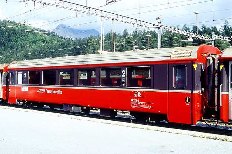 RhB - B 2492 am 20.08.1995 in Samedan - 2.Klasse verk�rzter Einheitspersonenwagen (Typ IV) f�r Bernin-Express mit braunen Fensterband  - �bernahme 28.10.1992 - SWA - Fahrzeuggewicht 17,00t - Sitzpl�tze 44 - L�P 14,50m - zul�ssige Geschwindigkeit 90 km/h - Logo RhB in italienisch- - Kennzeichnung an den Ecken gelbe Dreiecke - Hinweis: Die Fahrzeugserie besteht aus 7 Wagen mit den Nummern 2491 bis 2497. 
