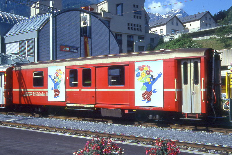 RhB - D 4225 - Gep�ckwagen am 05.6.1993 in Thusis - �bernahme 15.04.1980 - SWS/SWP - Fahrzeuggewicht 14,00t - Zuladung 8,00t - L�P 13,74m - zul�ssige Geschwindigkeit 90 km/h.- �2=16.09.1992 - RhB-Logo deutsch. Hinweis: d�nne Fahrzeugnummer, Fenstergurt nicht durchgehend, ohne Kennzeichnung an den Ecken, Werbeplakate Bahnhofseinweihung Thusis - die Gep�ckwagenserie bestand aus 8 Fahrzeugen mit den Nummern 4219 bis 4226
